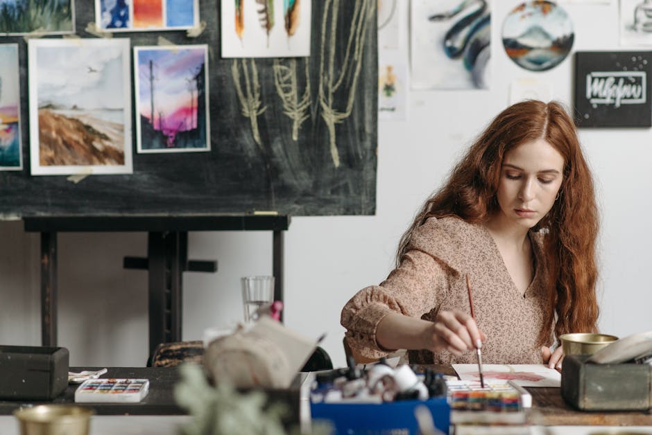 Artist focused on watercolor painting in a creative indoor art studio setting.