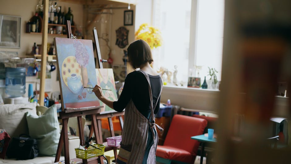 Woman artist painting in a cozy, light-filled art studio.